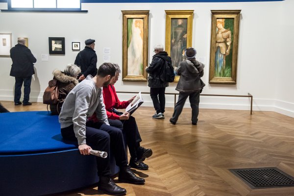 image avec des visiteurs assis devant des tableaux